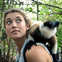 Photo of Alizé Carrère in the jungle with a lemur on her shoulder