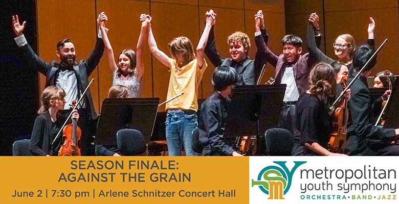 Photo of MYS musicians on stage holding raised hands/arms together