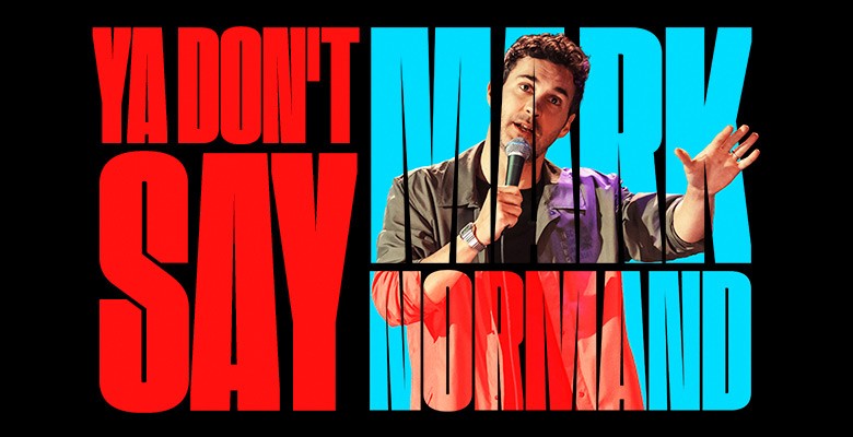 Photo of Mark Normand holding microphone, performing with "Ya Don't Say Mark Normand" in blue and red text