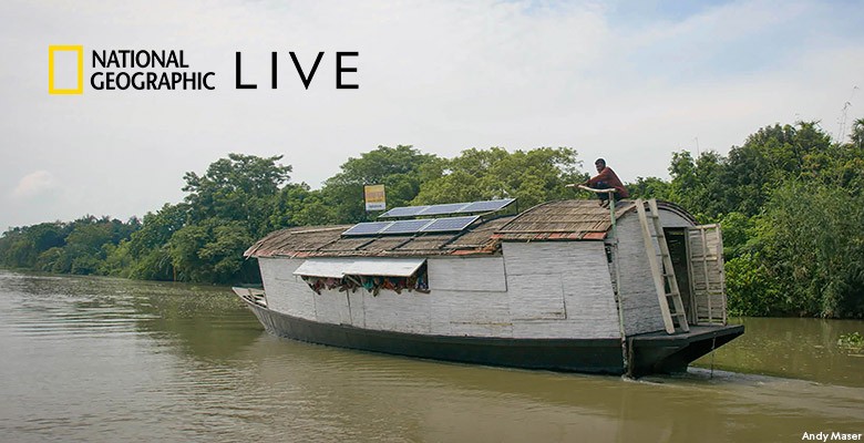 Photo of boat on river with solar panels on roof in Bangladesh