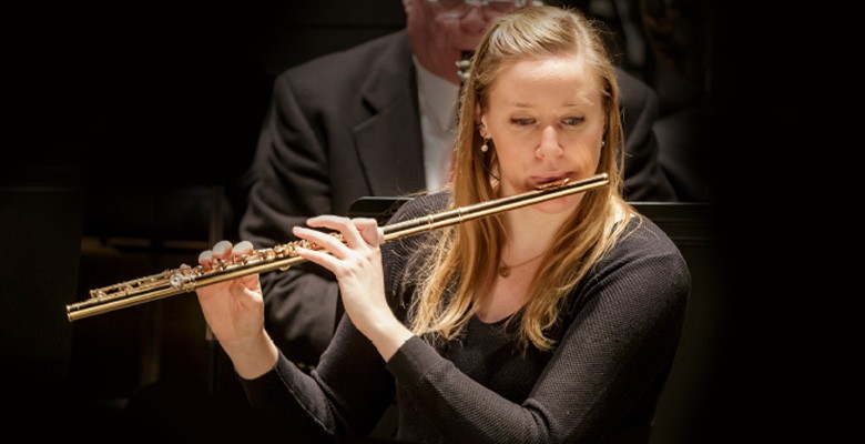 Photo of Martha Long playing flute in concert.