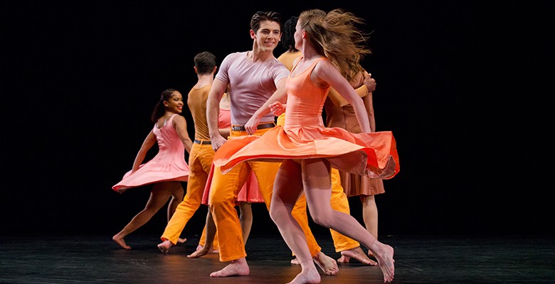 Photo of Paul Taylor Dance Co. performing on stage wearing bright pastel clothes