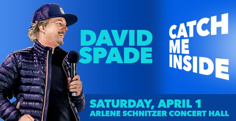 Photo of David Spade smiling, wearing puffy coat and trucker hat, holding microphone with name, tour, show info in text