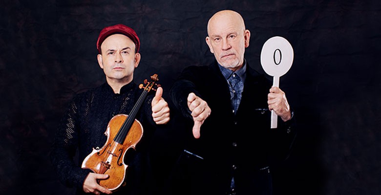 Photo of Aleksey Igudesman holding violin and Malkovich holding a sign with "0" on it
