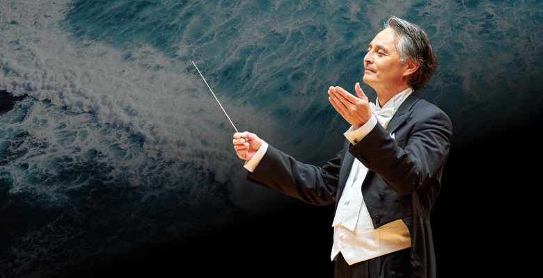 conductor smiling in front of grey backdrop