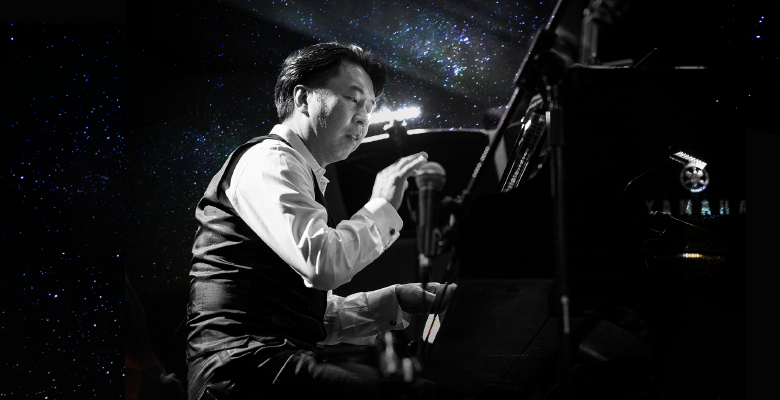 makoto ozone at piano in front of starry night sky