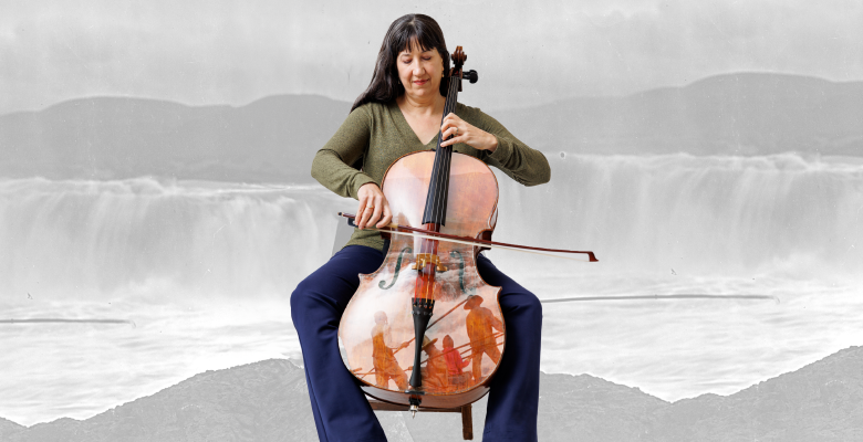 woman playing cello in front of grey backdrop of indigenous people in front of waterfalls