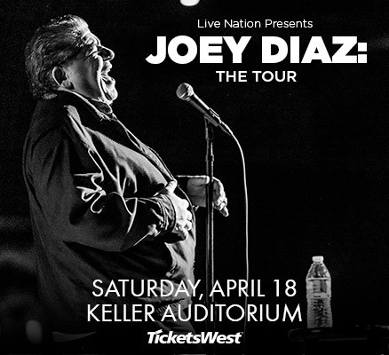 Black and white photo of Joey Diaz laughing next to a microphone.