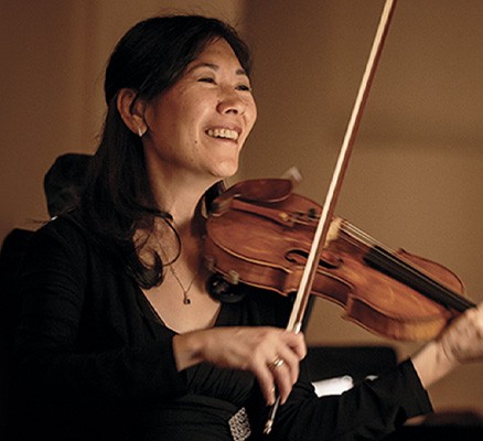 Photo of Sarah Kwak smiling and playing violin