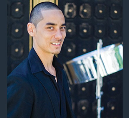 Photo of Andy Akiho smiling in front of a steel drum.