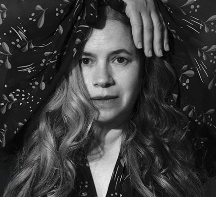 Black and white photo of Natalie Merchant - head shot w/ her hand over her head