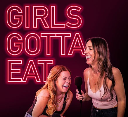 Girls Gotta Eat photo of Ashley and Rayna with "Girls Gotta Eat" in neon lights