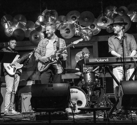 Balck and white photo of Bikini Drone members performing on stage