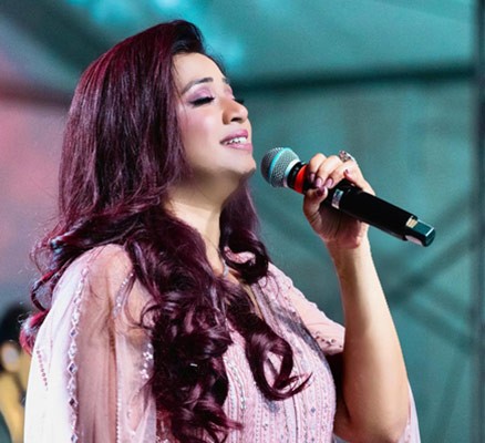 Photo of Shreya Ghosal singing holding microphone
