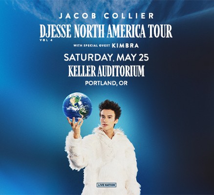 Photo of Jacob Collier on blue background, wearing a white furry coat 