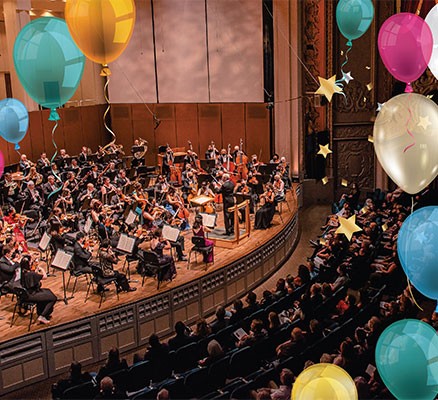 Photo of Oregon Symphony on stage at Schnitzer Hall with balloons in air