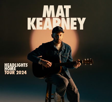 singer songwriter matt kearney on stool in front of name with black background