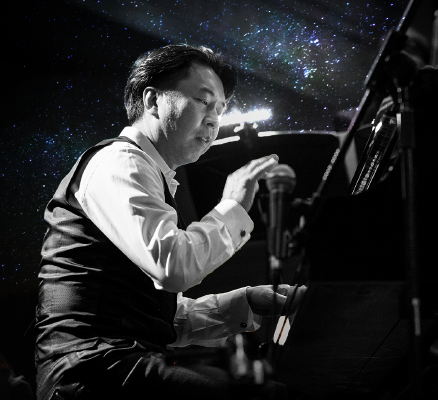 makoto ozone at piano in front of starry night sky