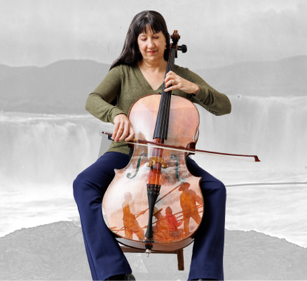 woman playing cello in front of grey backdrop of indigenous people in front of waterfalls