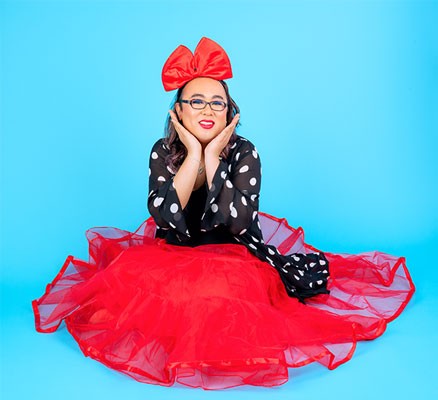 robin tran in red dress on blue background