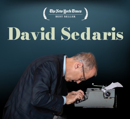 Photo of David Sedaris sitting with head down over typewriter, typing