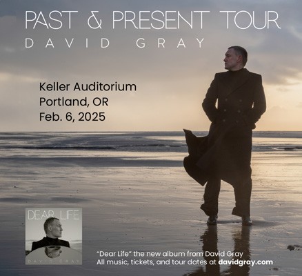 David Gray standing on a beach in a long overcoat at day break