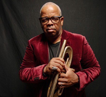 Professional photo of Terence Blanchard in front of a velvet curtain holding a trumpet.
