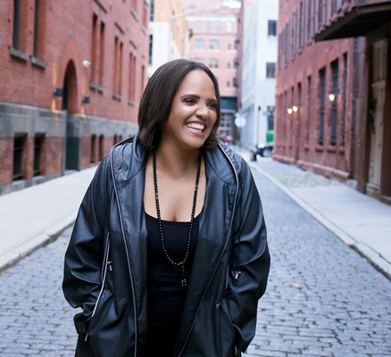 Photo of Terri Lynn Carrington standing on an empty city street and laughing