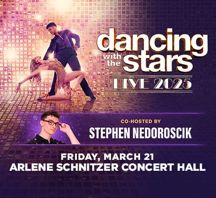 Two dancers pose in front of a reflective wall and mirror ball