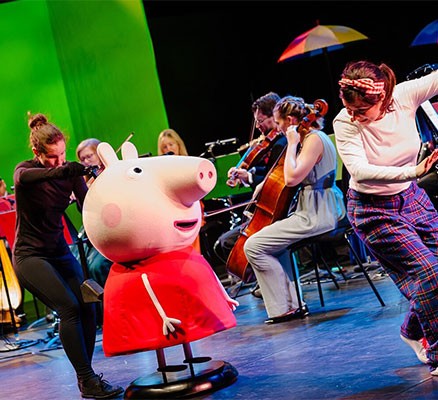 Photo of Peppa Pig on stage with orchestra members