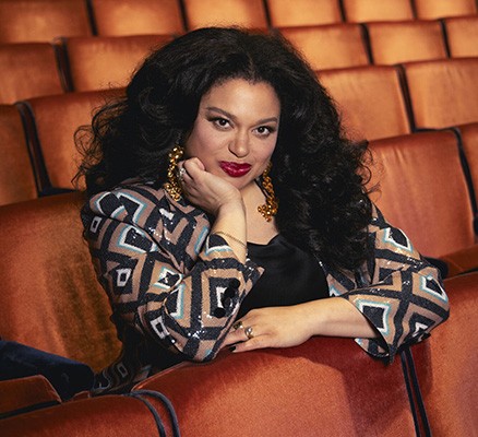 Photo of Michelle Buteau sitting in theater seats