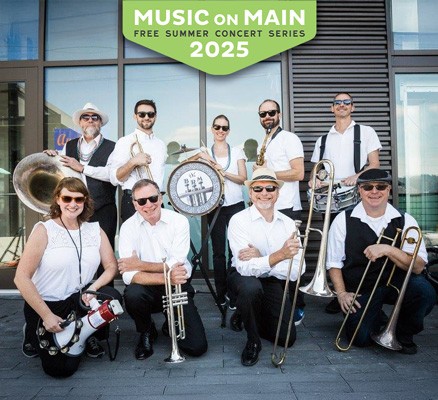 Members of the BrassRoots Movement band posed on a sidewalk with a Music on Main logo at the top.