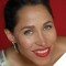 Photo of China Forbes smiling against a red backdrop.