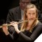 Photo of Martha Long playing flute in concert.