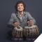 Photo of Zakir Hussain sitting playing drums with his hands