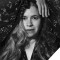 Black and white photo of Natalie Merchant - head shot w/ her hand over her head