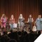 Photo of the women of She's Speaking performing together on stage