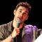 Photo of Mark Normand holding microphone, performing