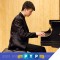 Photo of PYP musician Hansen Barrett sitting at piano playing
