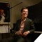 Photo of Ben Folds sitting with his back to a piano