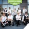 Members of the BrassRoots Movement band posed on a sidewalk with a Music on Main logo at the top.